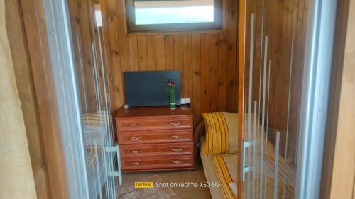 a room with a tv on a dresser with a window at apartament w ogrodzie in Głuchołazy