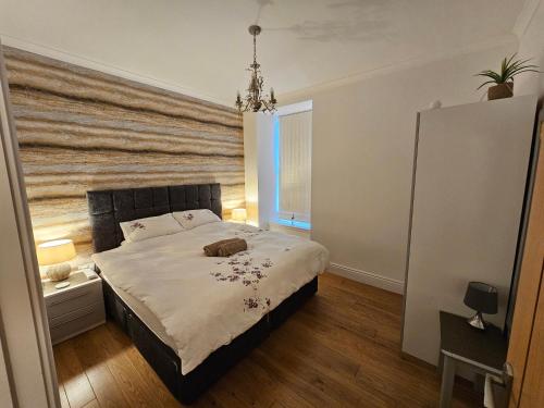 a bedroom with a large bed with a wooden wall at Craigielea Apartment 3 in Lerwick