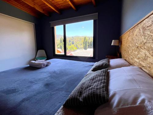 1 dormitorio con 1 cama grande y ventana grande en Departamento Andes BIancos, luminoso y con excelentes vistas en SMA! en San Martín de los Andes