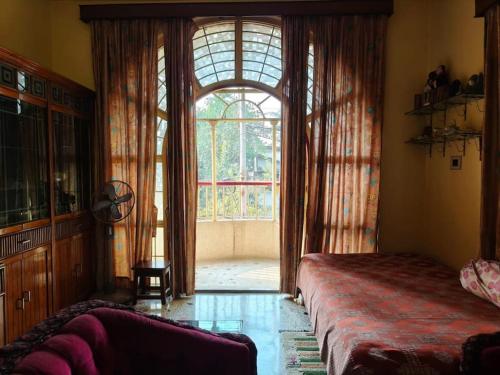 kolkataにあるPremium Apartment, Kolkata Airportのベッドと大きな窓のある寝室