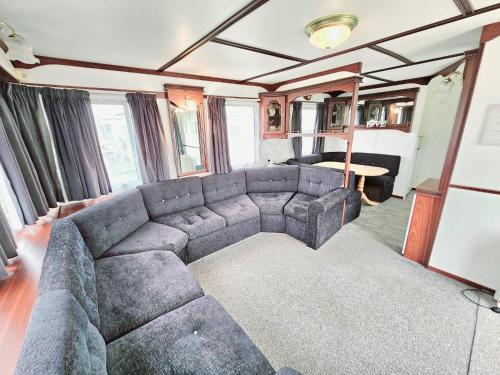 a living room with a couch in a train car at Golden Anchor 8b9 Caravan Park Holiday Home in Chapel Saint Leonards