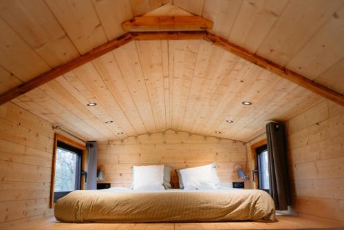 Ce lit se trouve dans une petite chambre dans une cabane dans les arbres. dans l'établissement Berta Tiny house, à Verlaine