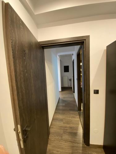 a hallway leading into a room with a wooden door at ΙΣΟΓΕΙΟ ΕΠΙΠΛΩΜΕΝΟ ΔΙΑΜΕΡΙΣΜΑ in Dhirrévmata