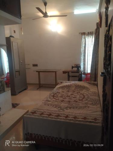 um quarto com uma cama e uma ventoinha de tecto em Parthasarathy Home stay em Trivandrum