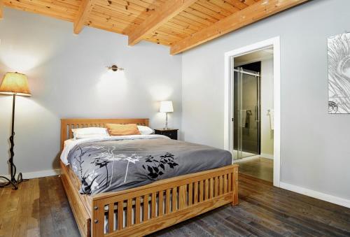 - une chambre avec un grand lit et un cadre en bois dans l'établissement Chalets Alpins - 11 Chemin des Skieurs, à Stoneham