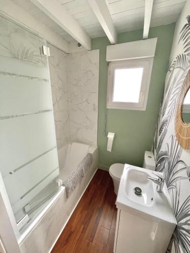 une salle de bain avec un lavabo, une baignoire et des toilettes dans l'établissement Agora Logement à 100 m de la plage, à Wimereux