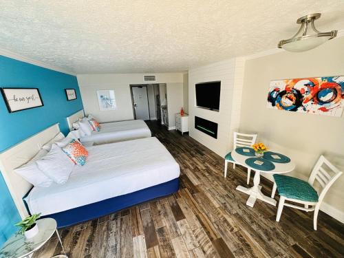 a bedroom with two beds and a table and a tv at Sea La Vie Oceanfront Studio in Myrtle Beach
