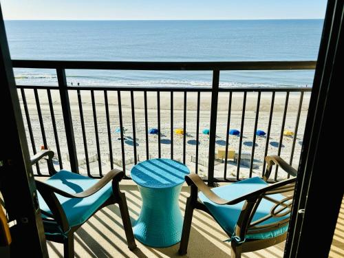 a balcony with two chairs and a table on the beach at Sea La Vie Oceanfront Studio in Myrtle Beach