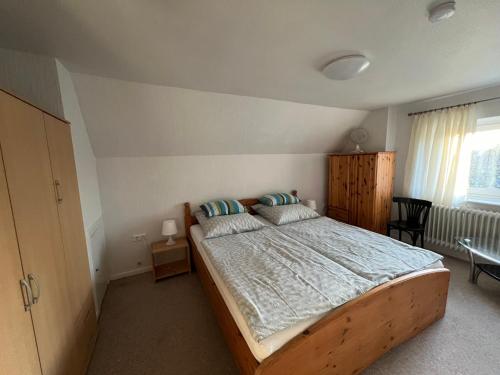 ein Schlafzimmer mit einem großen Holzbett in einem Zimmer in der Unterkunft Weesby Süderstraße 3.2 in Weesby