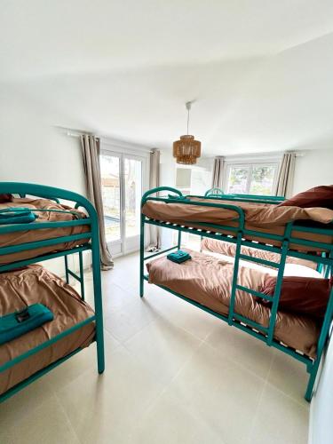 deux lits superposés dans une chambre avec fenêtre dans l'établissement Villa bassin d’Arcachon Notre Hutte, à Gujan-Mestras