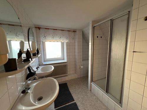 a bathroom with two sinks and a shower at Weesby Süderstraße 3.2 in Weesby