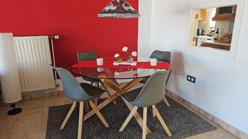 mesa de comedor con sillas y pared roja en Ferienhaus mit Privatpool für 4 Personen 2 Kinder ca 120 qm in La Victoria de Acentejo, Teneriffa Nordküste von Teneriffa, en La Victoria de Acentejo