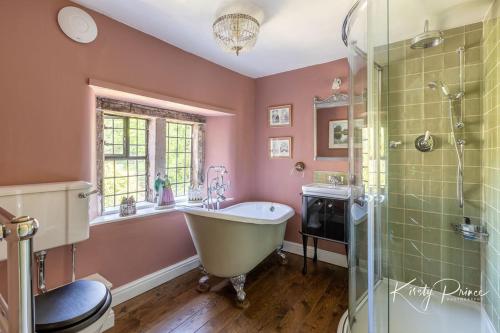 a bathroom with a tub and a shower and a sink at Rock House BNB in Bakewell