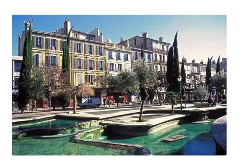 un bâtiment avec une fontaine au milieu d'une rue dans l'établissement Appart plein cœur de Marseille, à Marseille