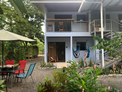 une maison avec un balcon, une table et des chaises dans l'établissement Habitación Equipada a 26 kilómetros de Jaco, Tulín Azul, 