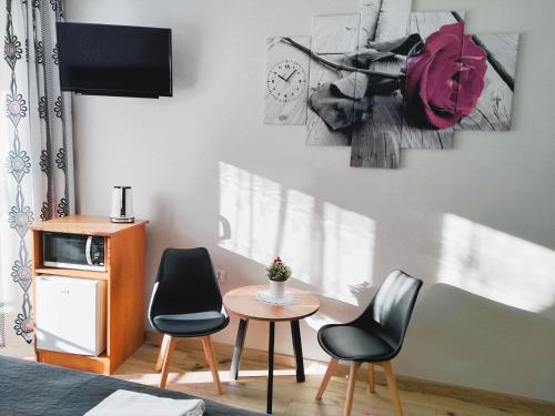 a room with two chairs and a table and a clock at Pokoje Gościnne " W zasięgu Tatr" in Kościelisko