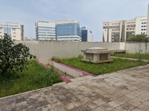 a park with a bench in the middle of a city at Tom I Lilas Clinique Pasteur in Ariana