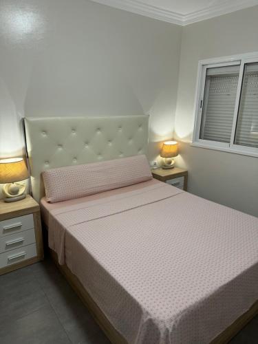 a bedroom with a large bed with two night stands at Apartamento Corralejo in Corralejo