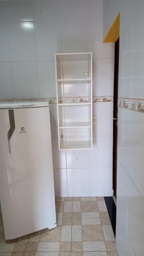 a kitchen with a white refrigerator in a room at Hospedagem do Neto in Saquarema