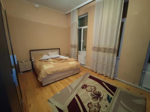 a small bedroom with a bed and a window at Sheki city villa in Sheki