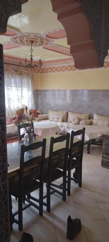 a living room with a table and chairs and a couch at Dar Ryma in El Jadida