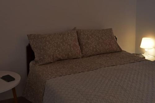 a bedroom with a bed with two pillows and two lamps at Διαμέρισμα Έλλη in Rethymno Town