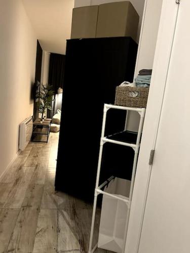Zimmer mit einer Leiter und einem schwarzen Kühlschrank in der Unterkunft High-quality flat near city in Brüssel
