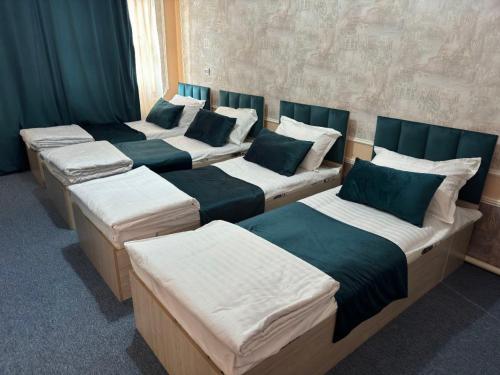 een groep van vier bedden in een kamer bij willa hostel in Yunusobod