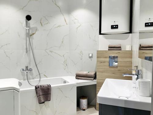 une salle de bain blanche avec un lavabo et une douche dans l'établissement Bright, newly renovated apartment, à Nice