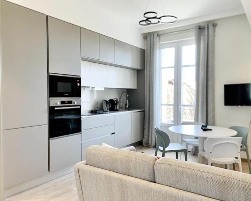 un salon avec un canapé et une cuisine avec une table dans l'établissement Bright, newly renovated apartment, à Nice