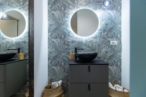 a bathroom with two sinks and two mirrors at PDS ROOMS in Brindisi