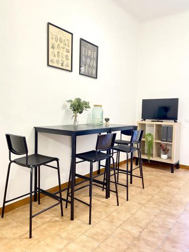 a dining room table with chairs and a television at Casa Ganza in Pisa