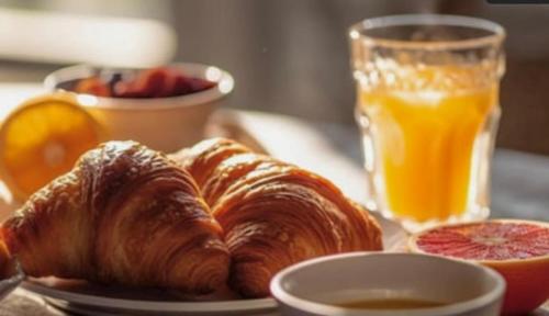 a plate of croissants and oranges and a glass of orange juice at Hotel Finca Malvasia - Adults only in Cabezón de Liébana