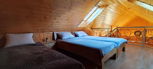 タウラゲにあるPakeliui/On the wayの木造キャビン内のベッドルーム1室(ベッド2台付)