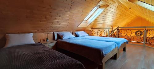 a bedroom with two beds in a wooden cabin at Pakeliui/On the way in Tauragė