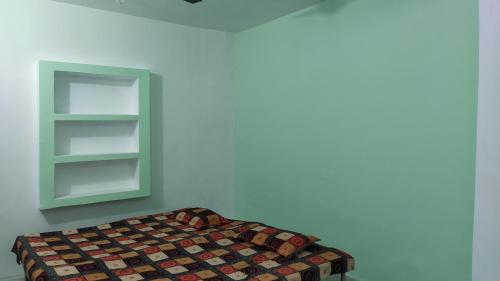 um quarto com uma cama e um armário verde em Vidhi Residency em Ayodhya