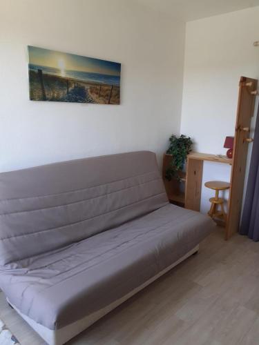 - un canapé dans une chambre avec une photo sur le mur dans l'établissement Studio - Marina 6 - 37 allée des pinons - 3-1, à Saint-Jean-de-Monts