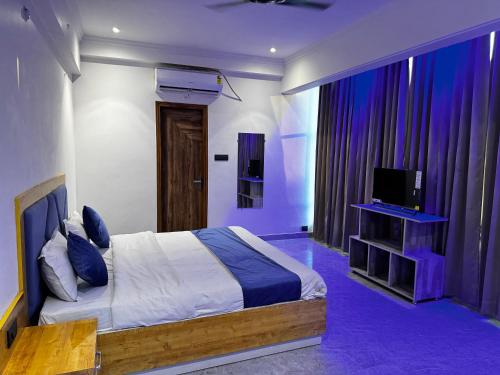 sypialnia z łóżkiem, telewizorem i zasłonami w obiekcie Hotel Daharm w mieście Lucknow