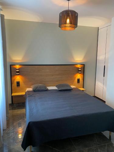 una camera con un grande letto con testiera in legno di Maison Paray- Orly- Parking Privé a Paray-Vieille-Poste