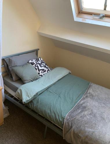 - un petit lit dans une chambre avec fenêtre dans l'établissement Room in CV1 Fargo Village Room with private bathroom, à Parkside