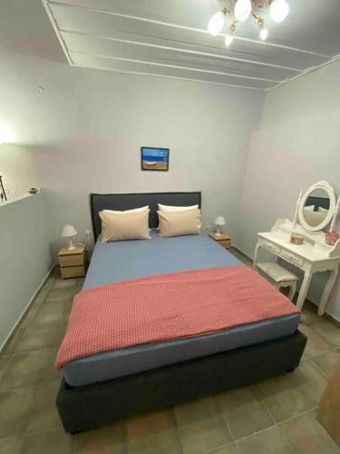 a bedroom with a bed in a room with a mirror at Zoe’s & Patty’s Guest House in Galaxidhion
