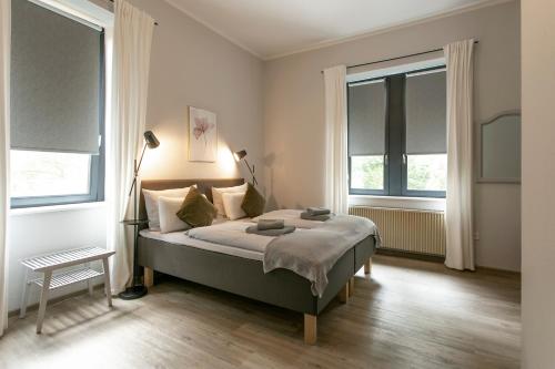 a bedroom with a bed and two windows at Schlosshotel Braunfels & Himmelreich in Braunfels