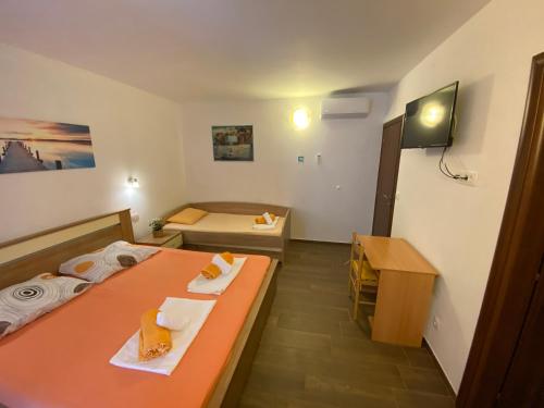 a small room with two beds and a desk at Apartment Toni in Duće