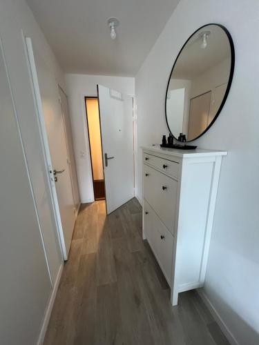 Cette chambre comprend une commode et un miroir mural. dans l'établissement Appartement 2 pièces proche commerces et transports, à Sevran