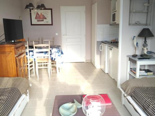 une cuisine et un salon avec une table et une salle à manger dans l'établissement Maison avec piscine et terrasse proche plage - FR-1-418-254, à Locmaria