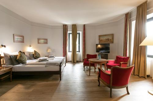 - un salon avec un lit, une table et des chaises dans l'établissement Schlosshotel Braunfels, à Braunfels