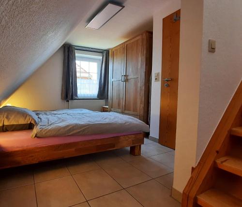 a small bedroom with a bed and a window at Ferienhaus Kolibri, exklusiv und familiär in Neßmersiel mit Anbindung nach Baltrum in Neßmersiel
