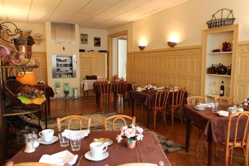 jadalnia ze stołami i krzesłami w obiekcie Hotel California w mieście Vichy