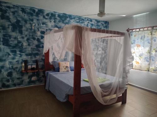 a bedroom with a bed with a canopy at Malaica in Kilifi