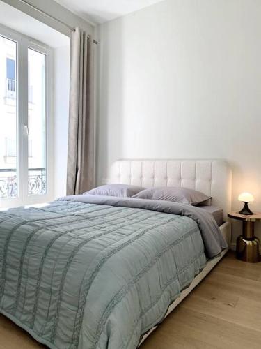 une chambre blanche avec un grand lit avec une fenêtre dans l'établissement Luxuriously furnished bright newly renovated oasis, à Nice